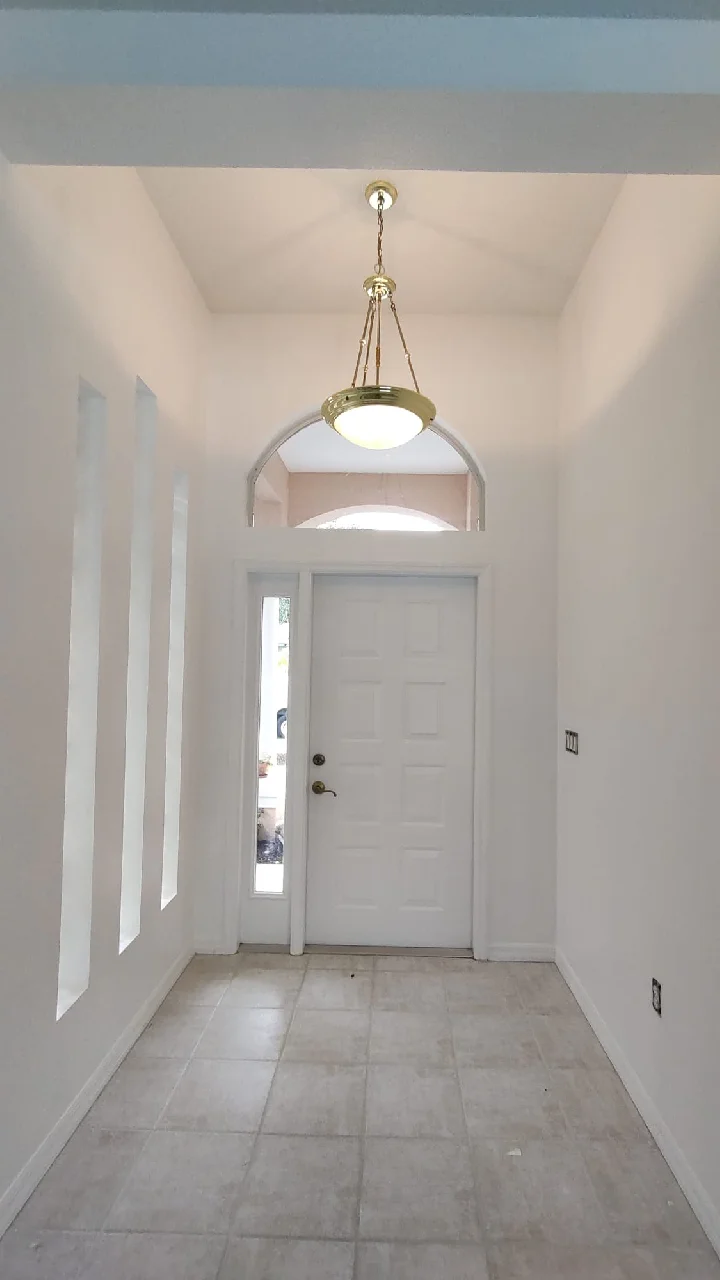 Freshly painted interior entryway with a white door and walls